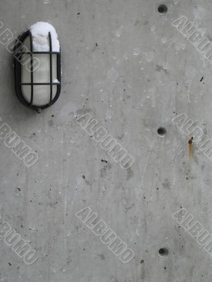 outdoor light with snow on a cement wall