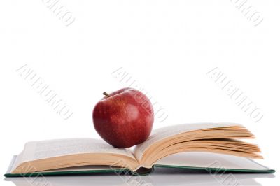 Red apple with open book and reflection