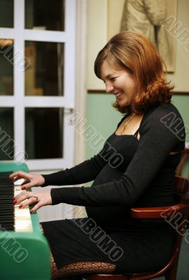 Pregnant woman plays on the piano