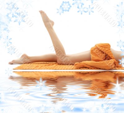 long legs of girl with orange towel on white sand