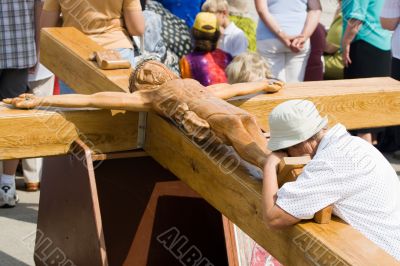 Praying woman at large wooden crucifix