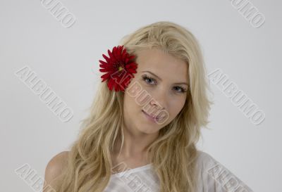pretty model with bright red flower in her hair