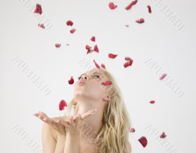 young caucasian lady blowing petals
