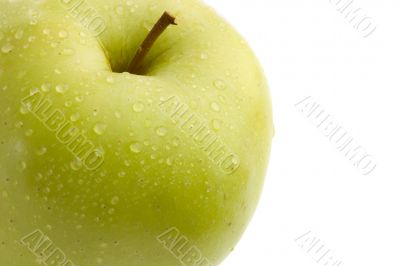 Green delicious apple with drops of water