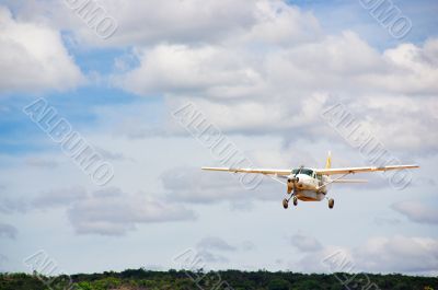 Small plane in cloudy sky