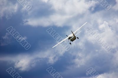 Small plane in blue cloudy sky