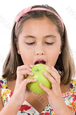 Adorable girl with flowered dress eating a apple