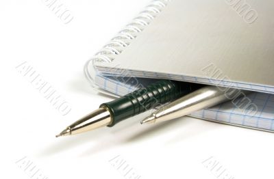 blank notebook and two pens