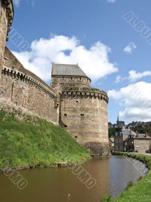Tower of an ancient castle and protecting ditch with water

