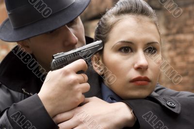 man threatens the woman with a pistol