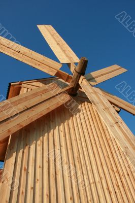 Rural wooden windmill against blue sky