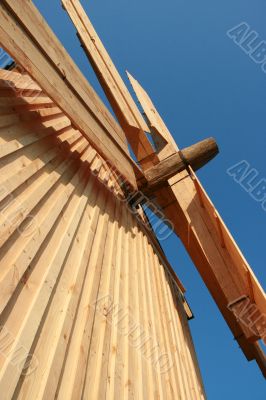 Rural wooden windmill against blue sky