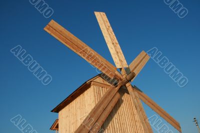 Rural wooden windmill against blue sky