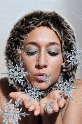Beautiful woman blowing snow