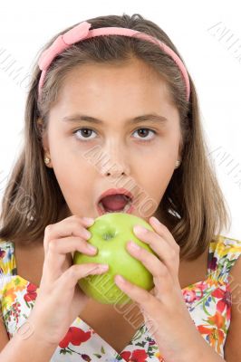 Adorable girl with flowered dress eating a apple