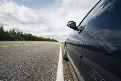 small blue car standing on the road side