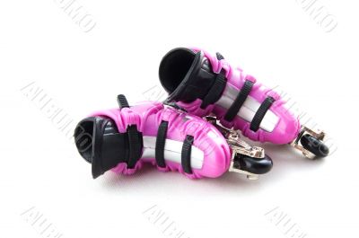 pink rollerblades laying on their side