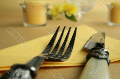 Knife and fork on yellow tablecloth