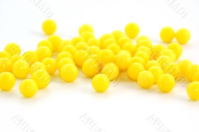 Many yellow pills on white