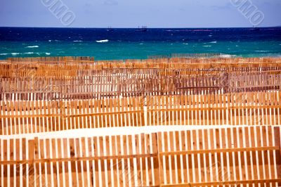 Wooden fence on deserted beach dunes