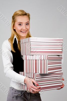 Smiling young woman with stack of boxes