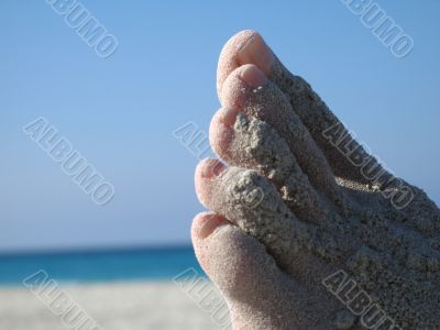 female foot covered with sand