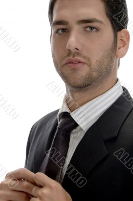 businessman holding tie and looking to camera
