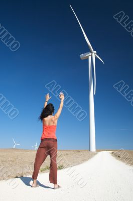 woman greeting wind energy mill