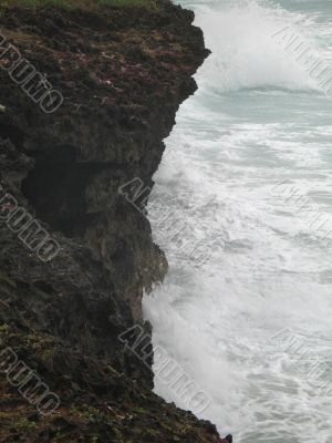 a cliff and angry caribbean ocean water