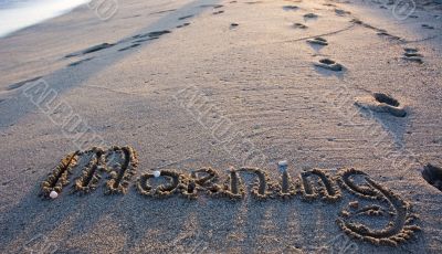 Word `morning` written on the sand