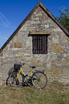 Bicycle with old stone house