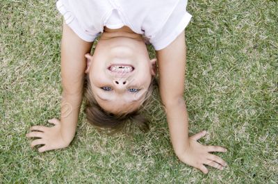 girl doing cartwheel in the grass