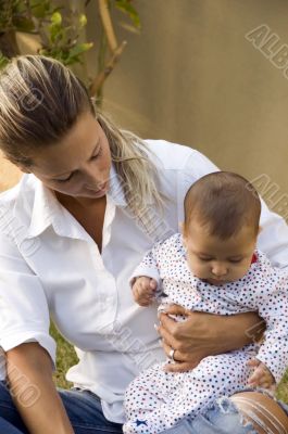 baby sitting on its mother`s lap