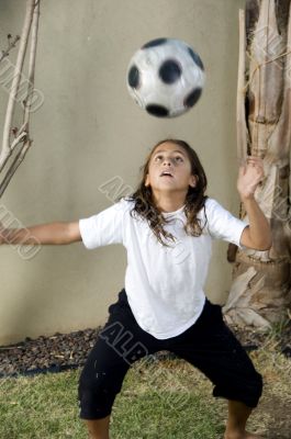 boy balancing football on his head