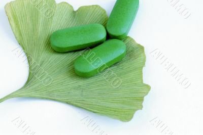 Closeup of pills and fresh Ginkgo Biloba leaves