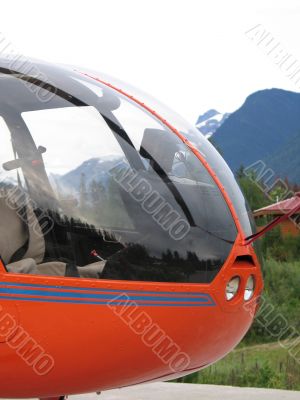 orange helicopter with mountain background