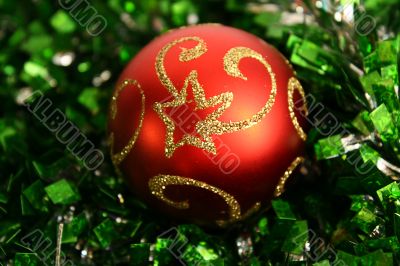 Red round sphere on a green tinsel