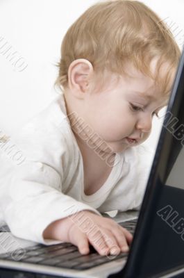 curious baby playing with laptop