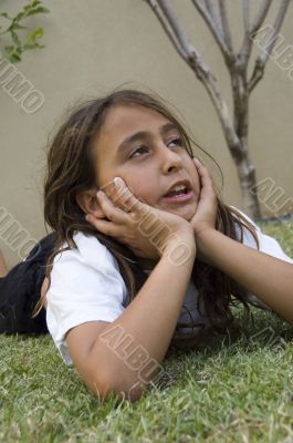 adorable boy lying on grass and looking aside
