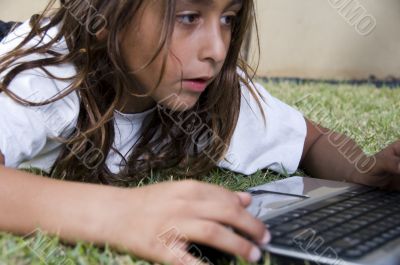 lying little american boy playing with laptop