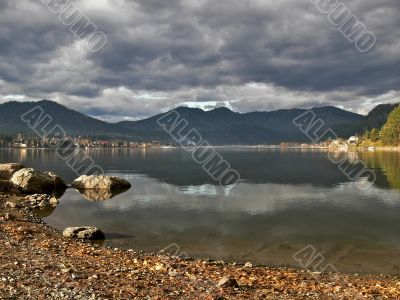 Coastline lake Teletskoe and cloudscape.