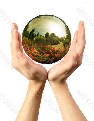 Woman hands holding a glass globe with nature reflection