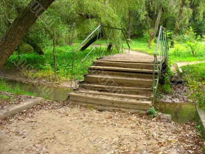 old bridge over a small river in autumn park