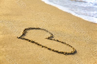 `Heart` drawing at sand, with sea wave