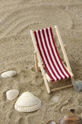 beach chair on the sand surrounded by shells
