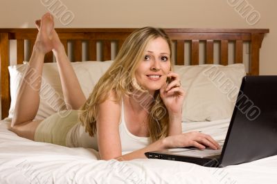 Woman on laptop on bed