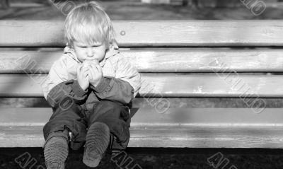 lonely child sits on a bench