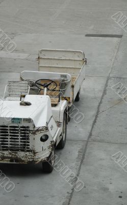 empty airplane gate with small trucks