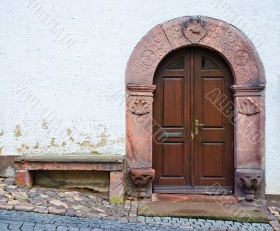 Entrance grey wooden door in a stone list