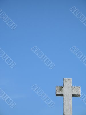 a stone cross and blue clear sky